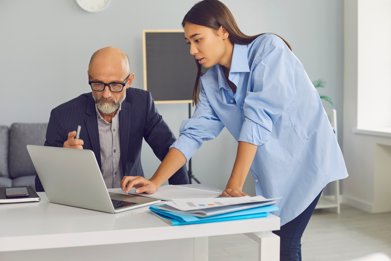 Diverse Young and Elderly Colleagues Using Laptop Computer Working on Company Project Together